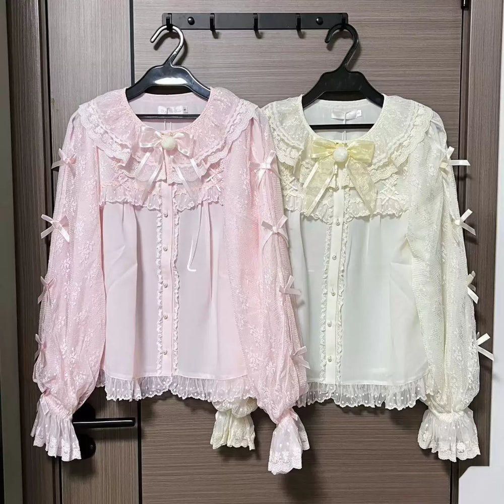 Pink lace blouse displayed on a hanger with layered bows and ruffled details.