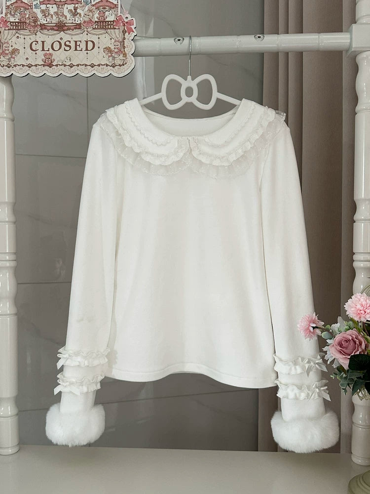 White long-sleeve inner top with a lace-trimmed rounded collar and ruffled bow cuffs hanging on a rack.