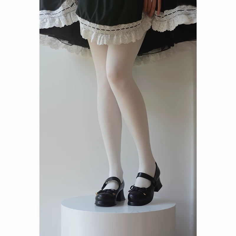 White pantyhose styled under a dark lace-trimmed skirt with Mary Jane shoes.