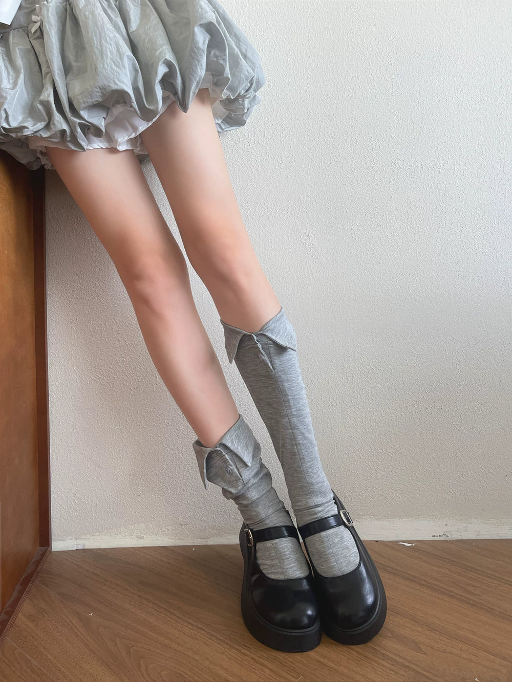 Grey scrunch socks with pointed collar details styled with black Mary Jane shoes.