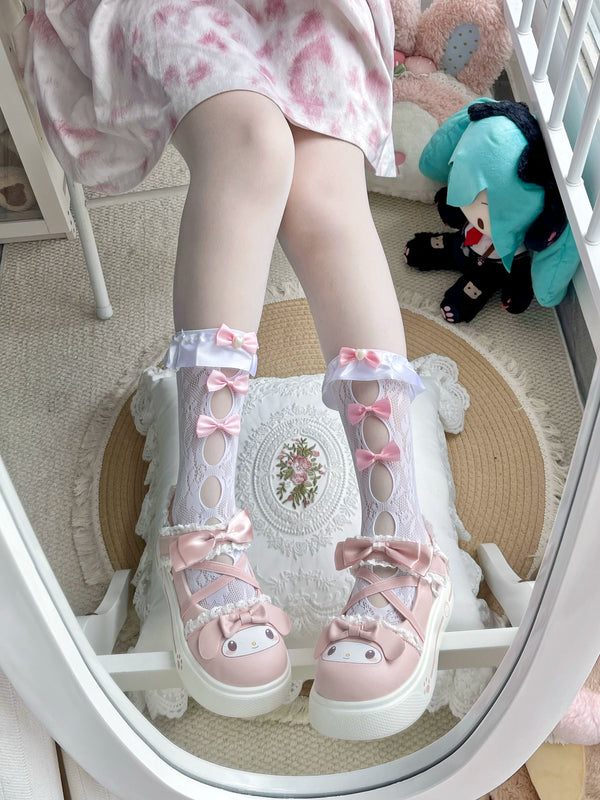 White lace mid-calf socks with pink bows and oval cutouts shown on a model.