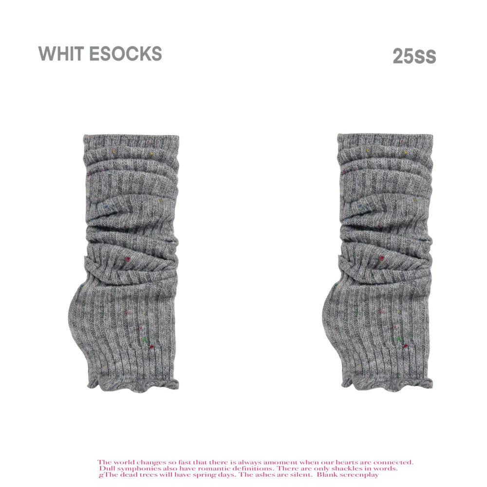 Grey scrunched leg warmers with small multicolour dots and red shoes.