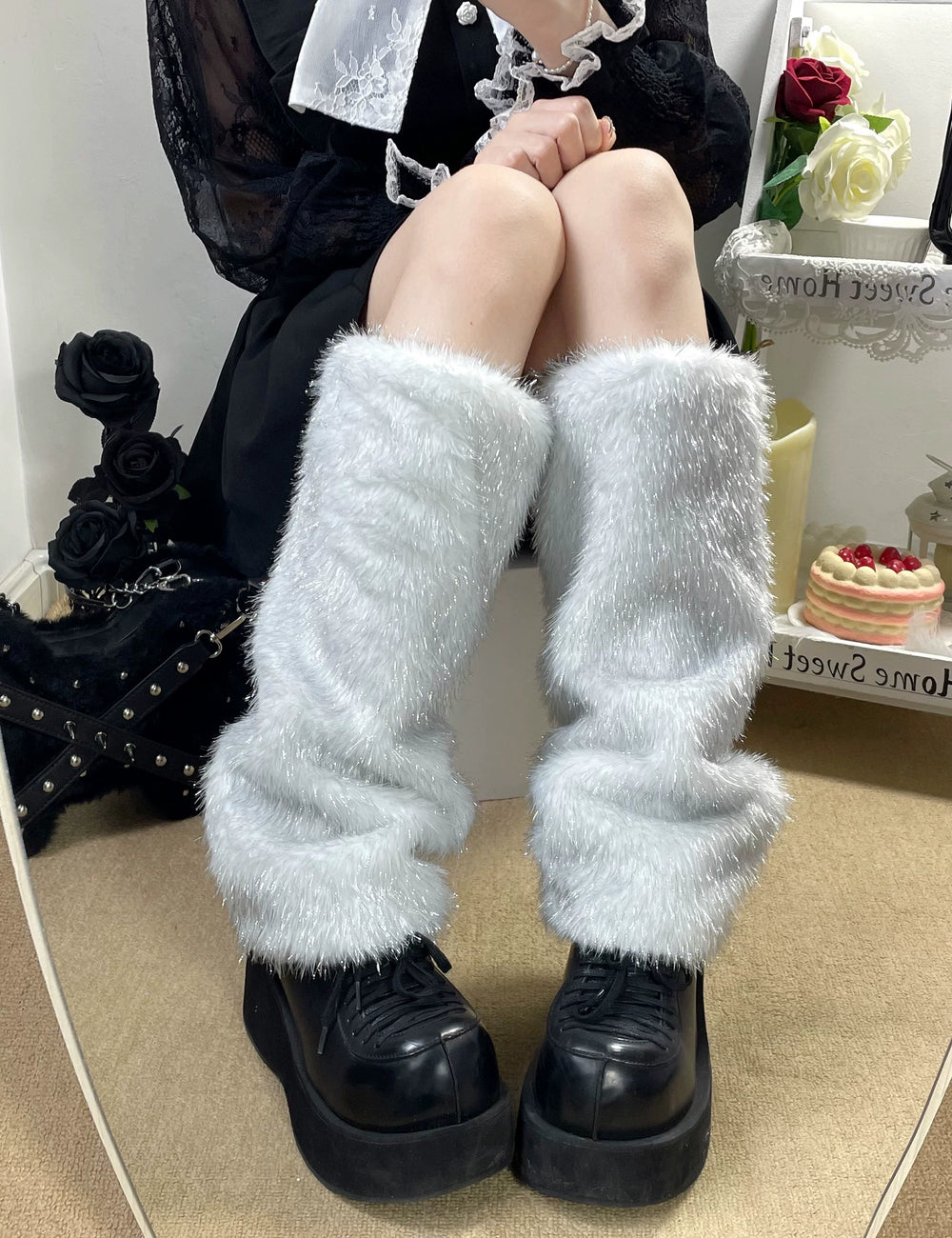 Model wearing white plush stacked socks over black platform shoes.
