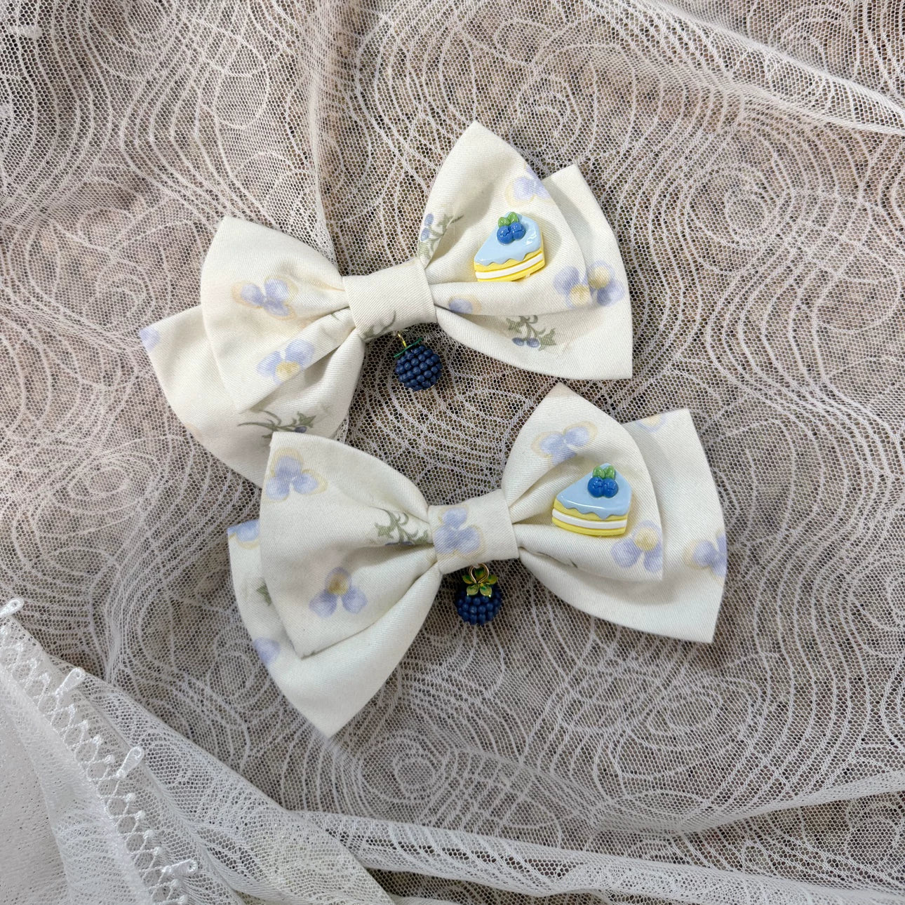 GZYRZ white bow side hair clips with blue blueberry and cake charms.