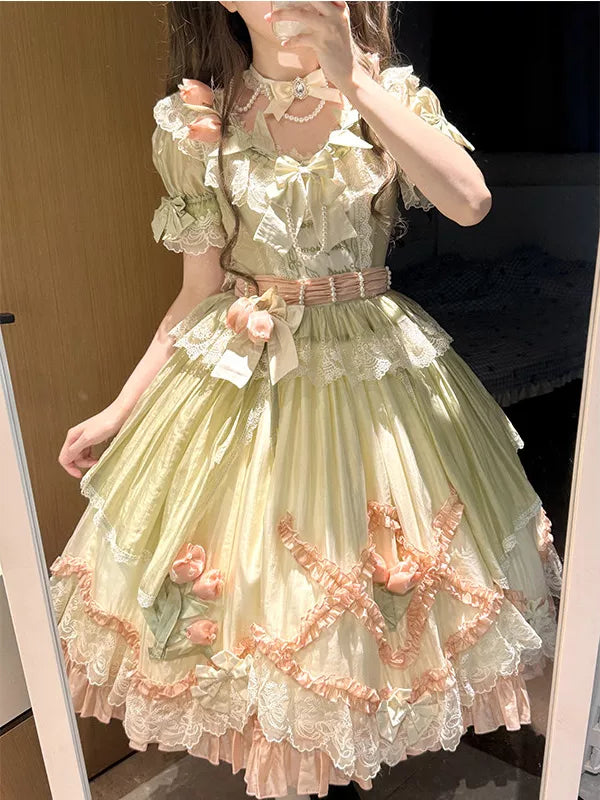 Green-and-pink Creamy one-piece dress with lace, bows and floral accents worn by a model