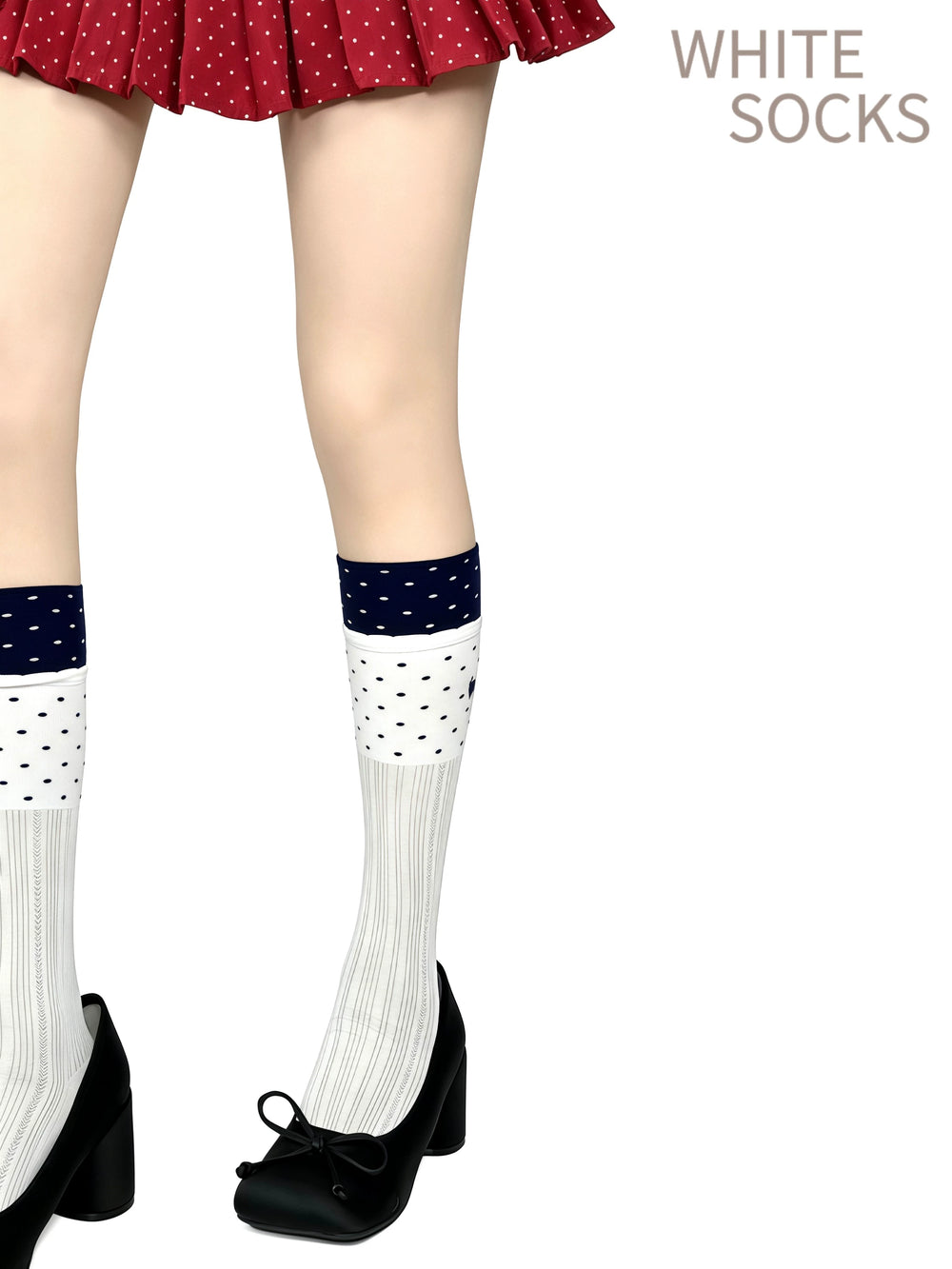 Navy-and-white polka-dot mid-calf socks with vertical stripe sections, styled with black shoes.