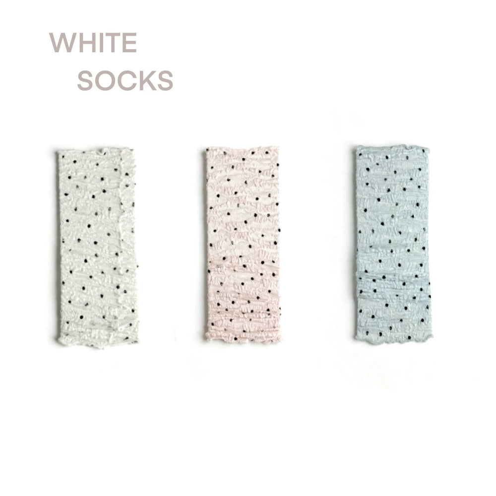 White, pink and blue polka-dot ruched leg warmers shown in product samples and on legs.