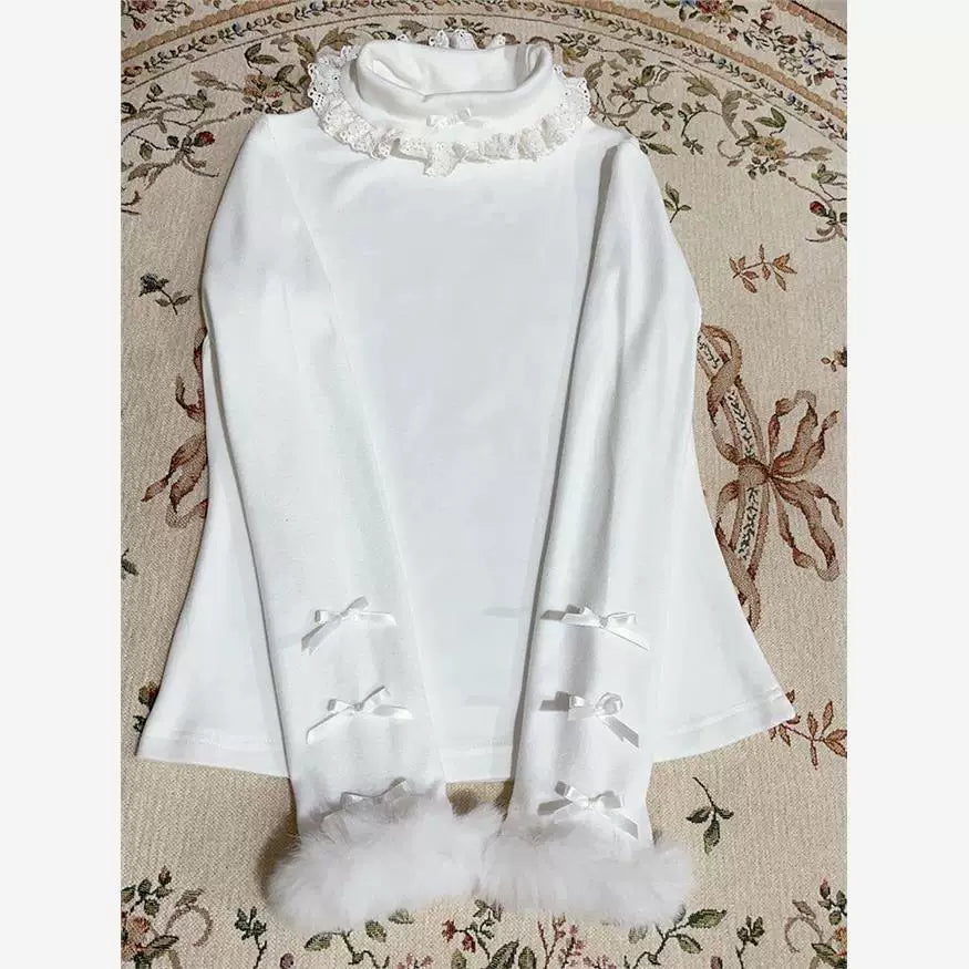 White long-sleeve knit base layer with a lace ruffle collar and flared cuffs, laid flat.