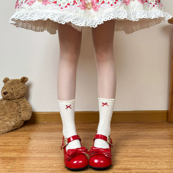 White mid-calf socks with red bow details styled with a strawberry print skirt and red shoes