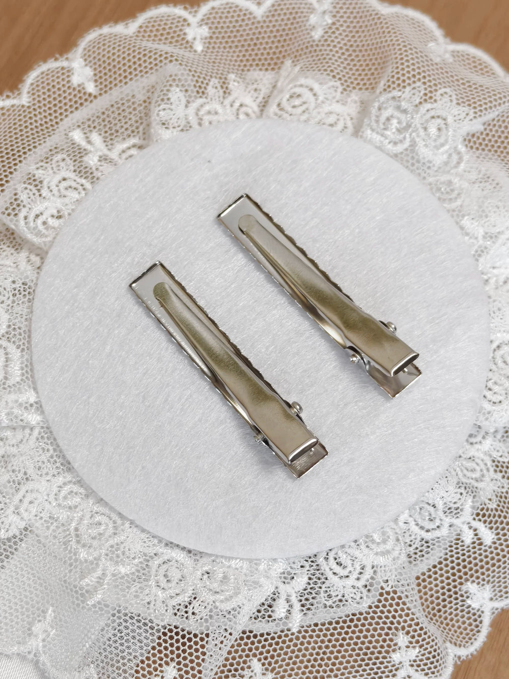 White Hanamaru accessory shown on lace with silver clips