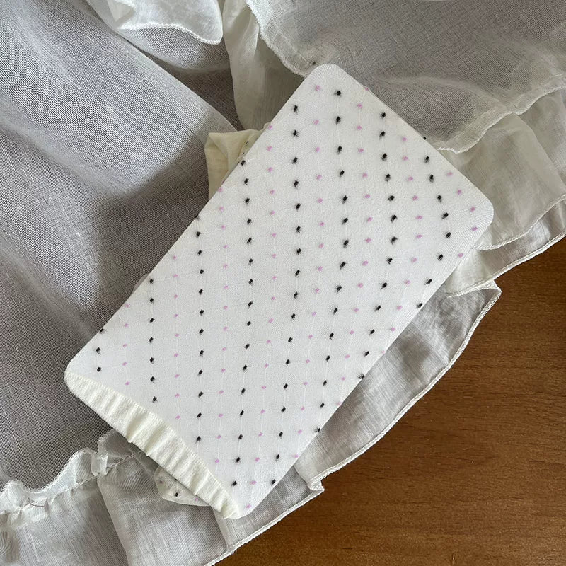 Pale pink polka dot sheer tights paired with a cream ruffled Lolita skirt