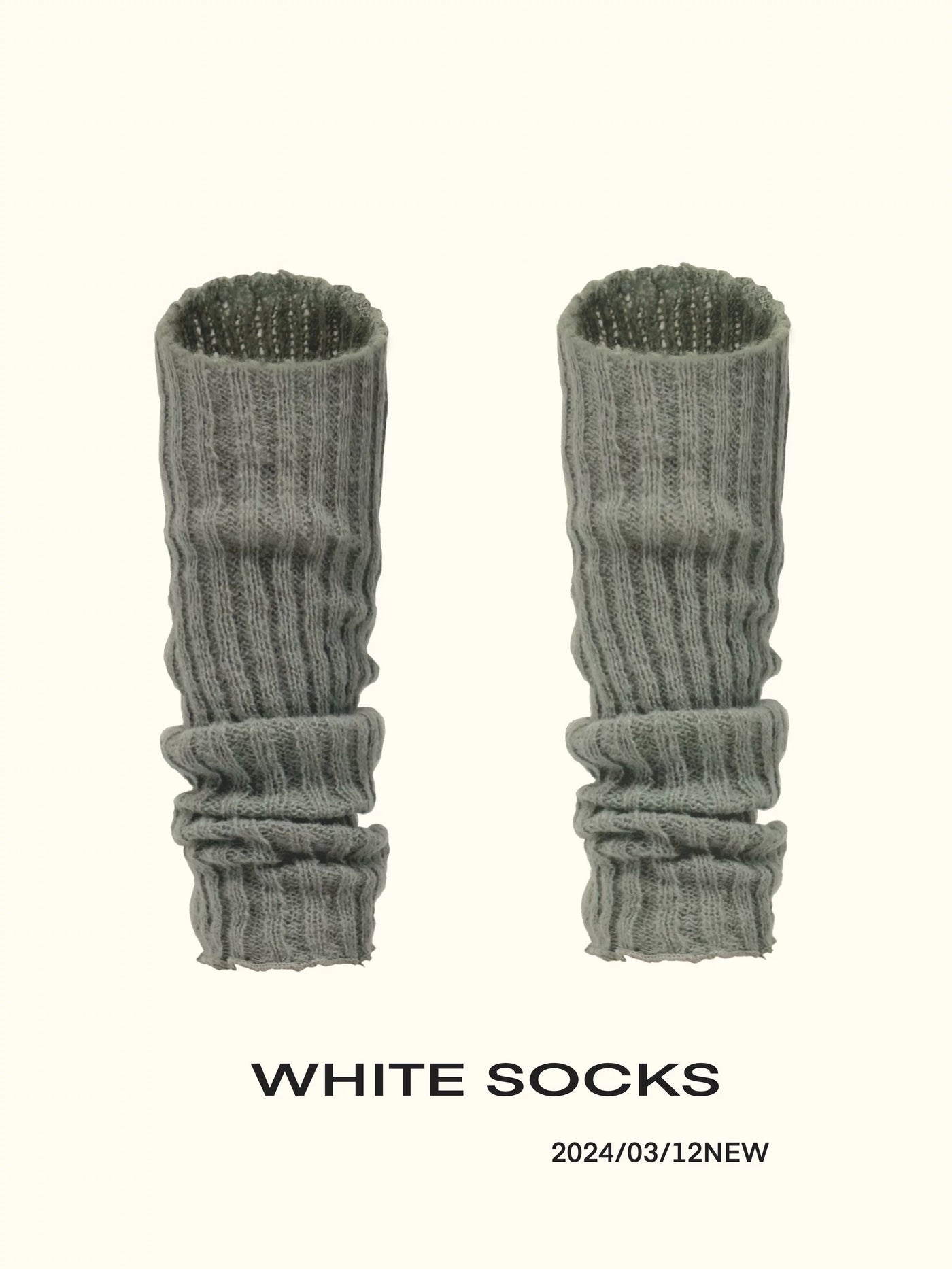Ribbed slouch leg-warmer socks shown in grey, white, and black colourways.