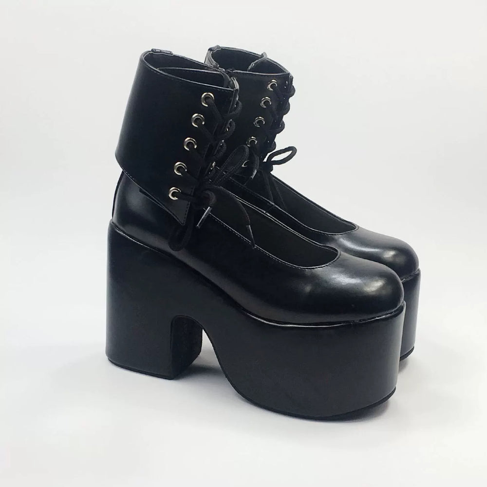 Black high-platform shoes with round toes, ankle lacing and ultra-high soles