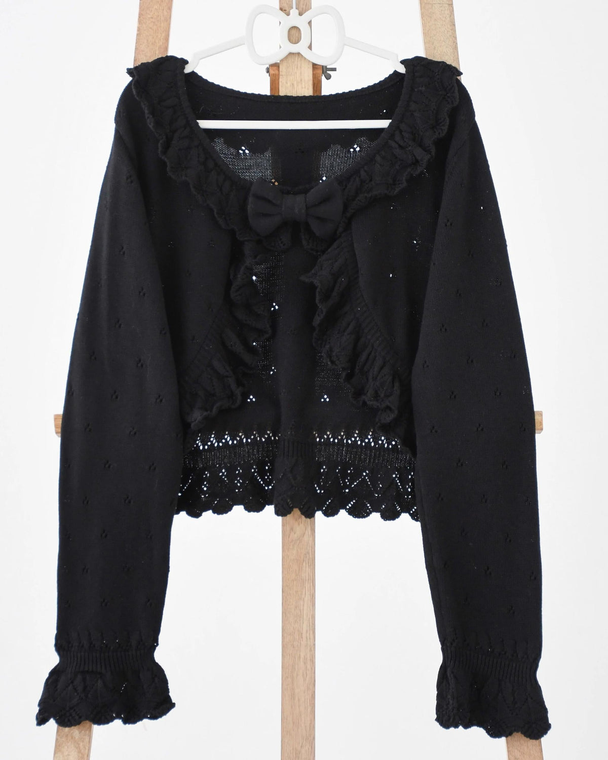Light green knitted Lolita cardigan with openwork pattern, ruffles and bow.