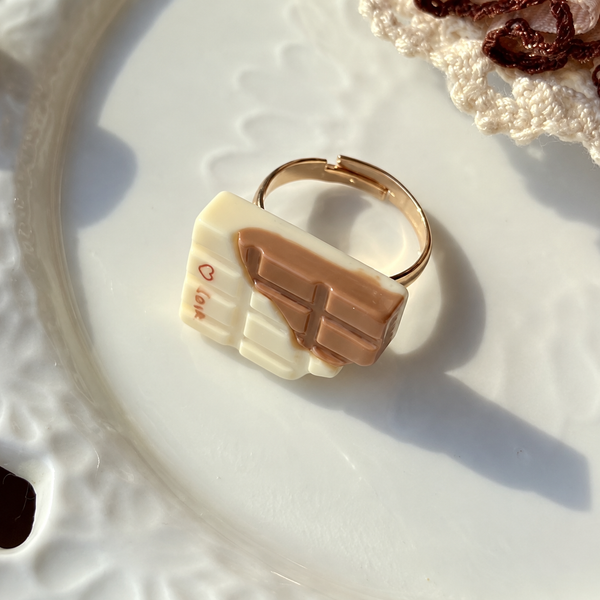 Bear doll milk chocolate adjustable ring, close-up of the cream and brown chocolate charm and gold-tone band.