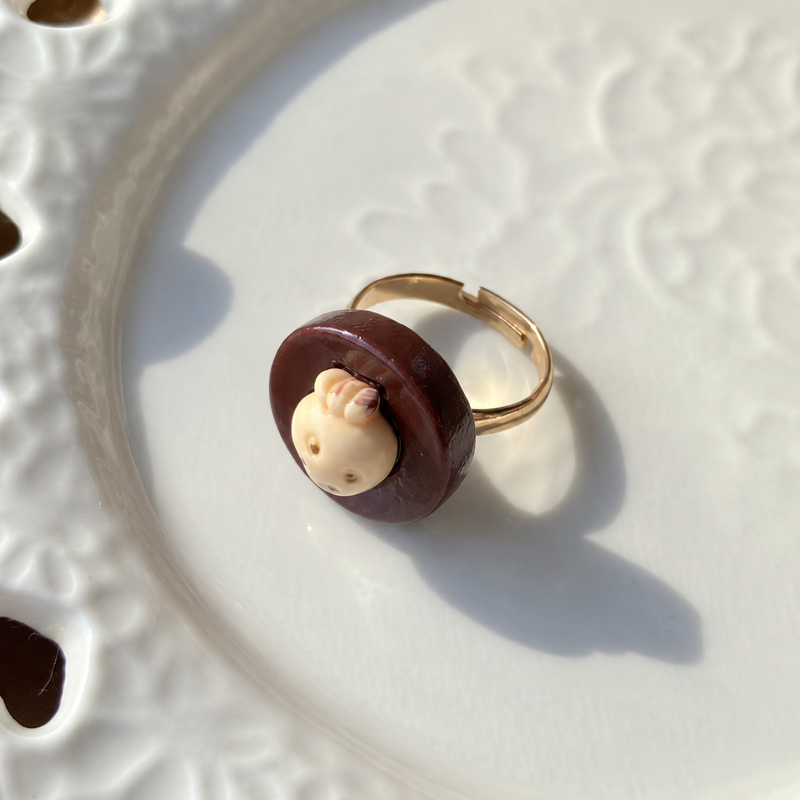 Bear doll strawberry filled chocolate adjustable ring, close-up showing the charm and gold-tone band.