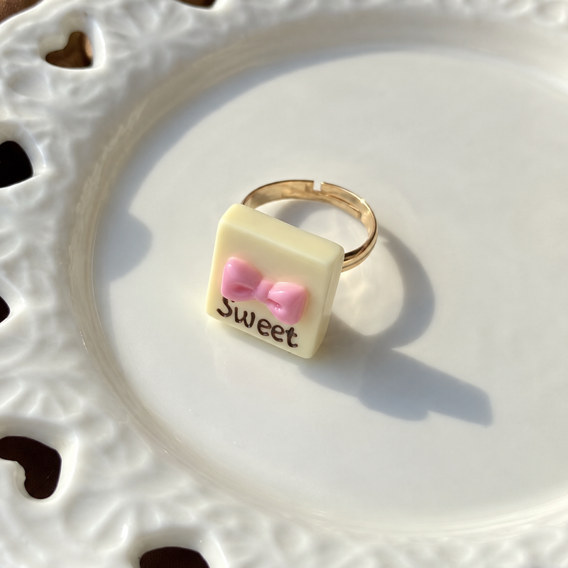 Bear doll white chocolate square adjustable ring, close-up showing the charm and gold-tone band.