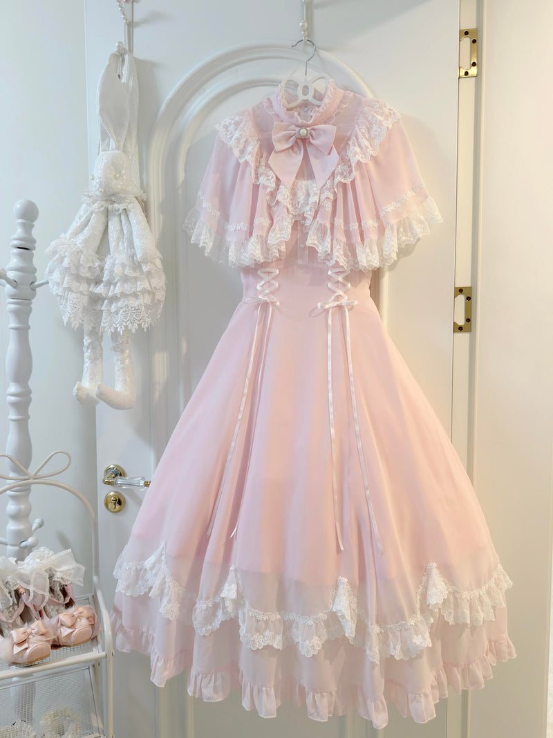 Pale pink lace capelet lolita dress with white trim and pearl bow, front view