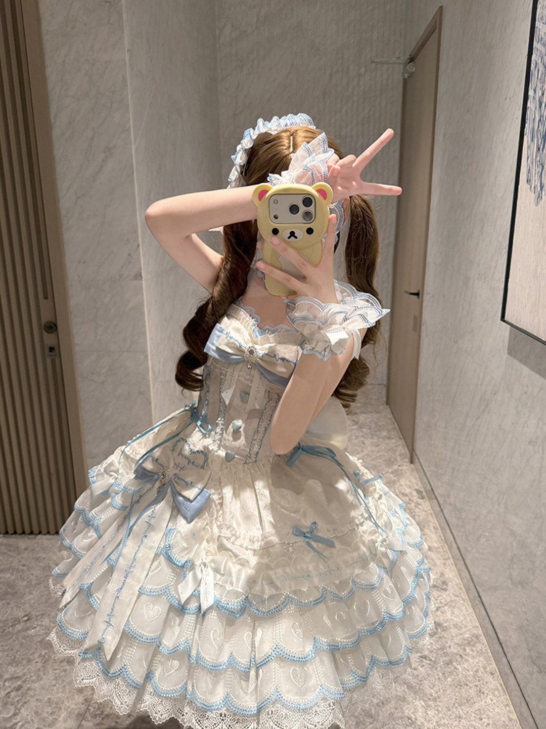 Detail view of blue and white sweet lolita JSK waist bow and heart-shaped bodice embellishments