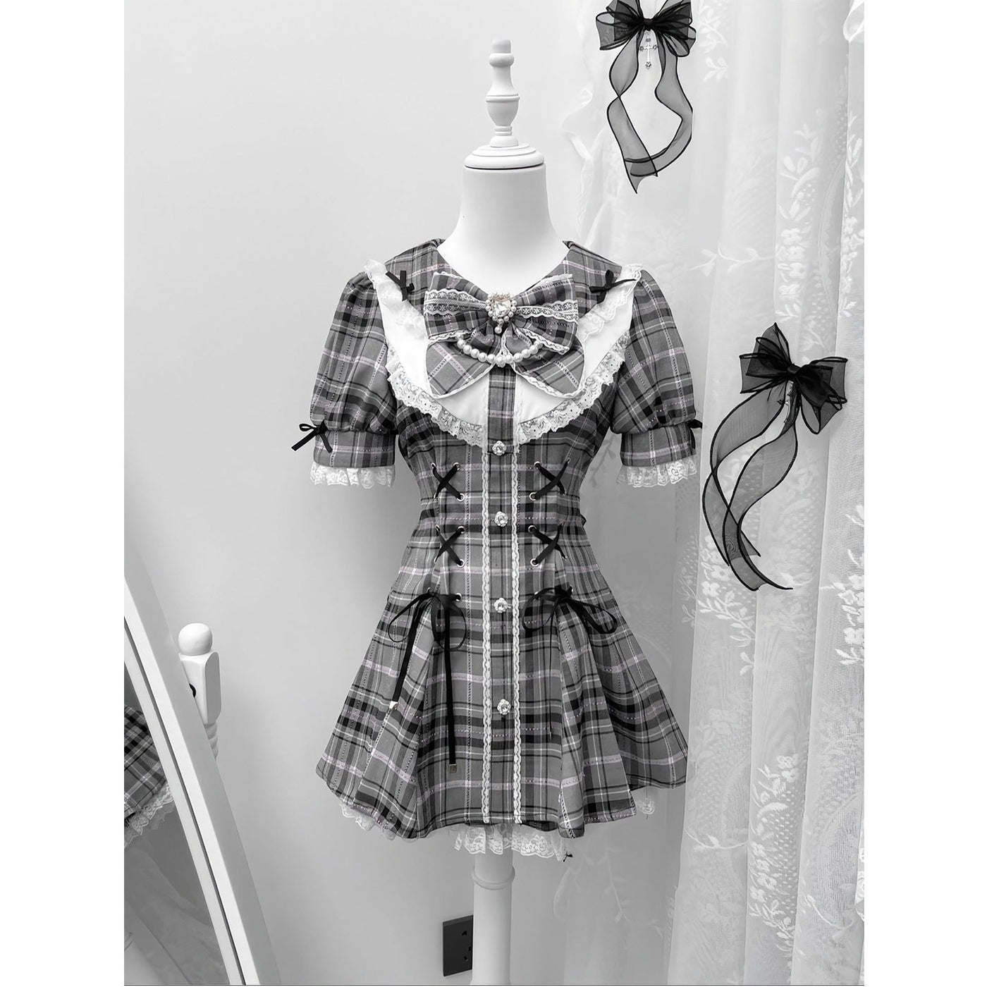 Grey plaid dress with lace trim, ribbons and a large neckline bow.