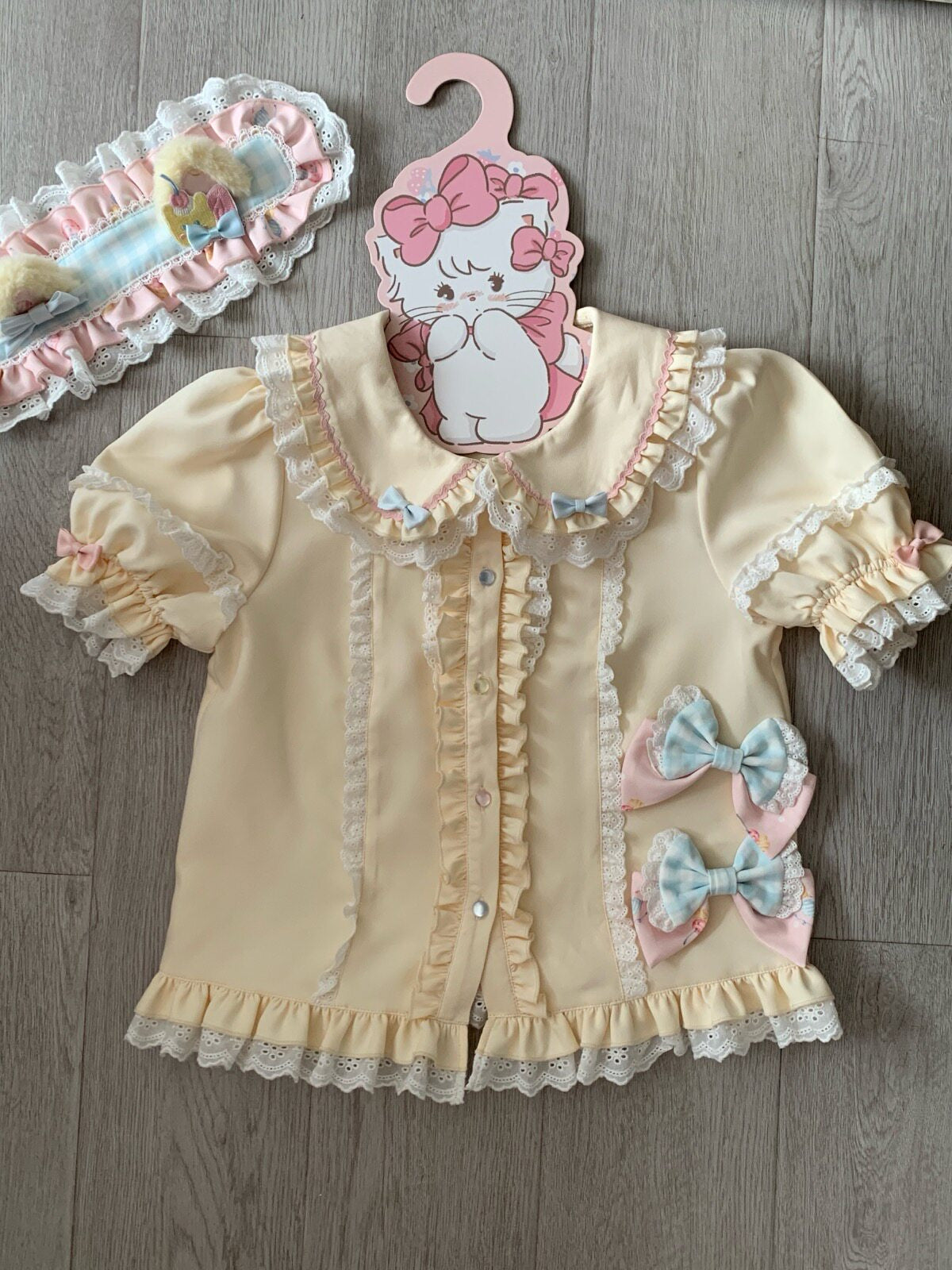 Pastel Sweet Lolita jumper skirt with all-over dessert print, tiered ruffled skirt, and central multi-fabric bow