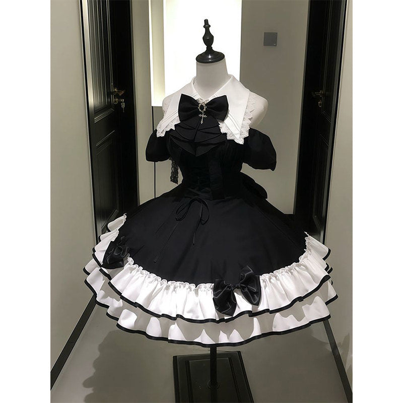 Black off-shoulder dress with white collar and tiered ruffle hem on a mannequin.
