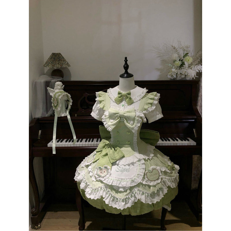 Green and white apple-themed dress set on a dress form.