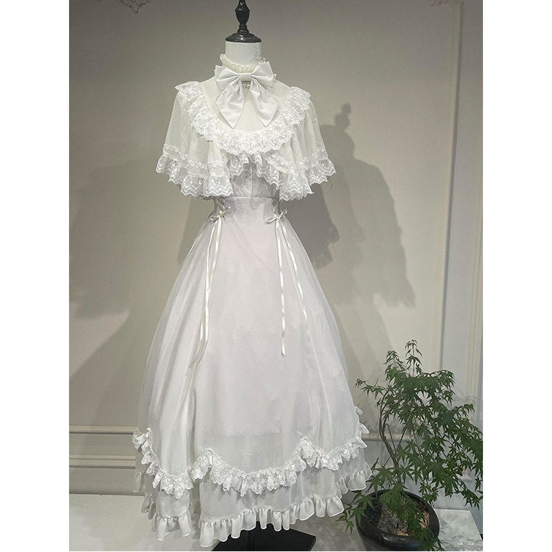 White lace-trim dress with capelet, bow neckline and ruffled hem.